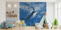 Large whale wallpaper mural behind a white play tent in a bright bedroom.