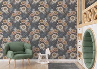 Gray floral wallpaper on a nursery wall with a green armchair and wooden toys.