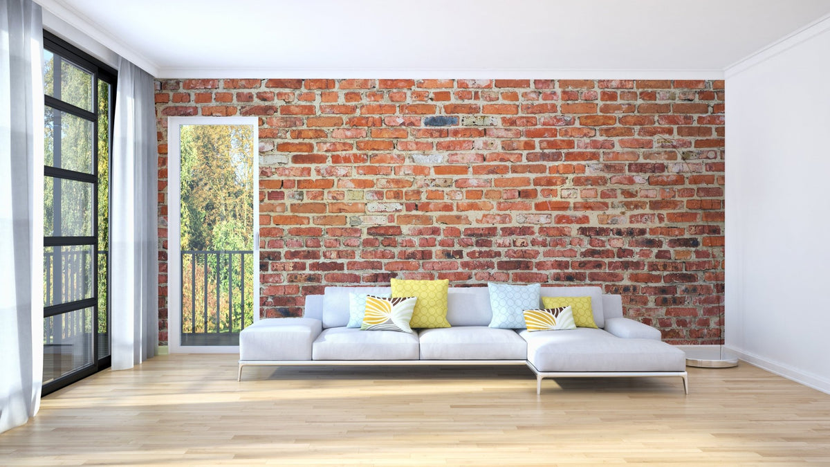 Large living room with white sectional sofa and brick wall mural.