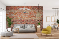 Modern living room with grey furniture and exposed red brick wall mural decor.