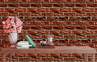 Textured brick wallpaper in a dining area with pink flowers on a wooden table.