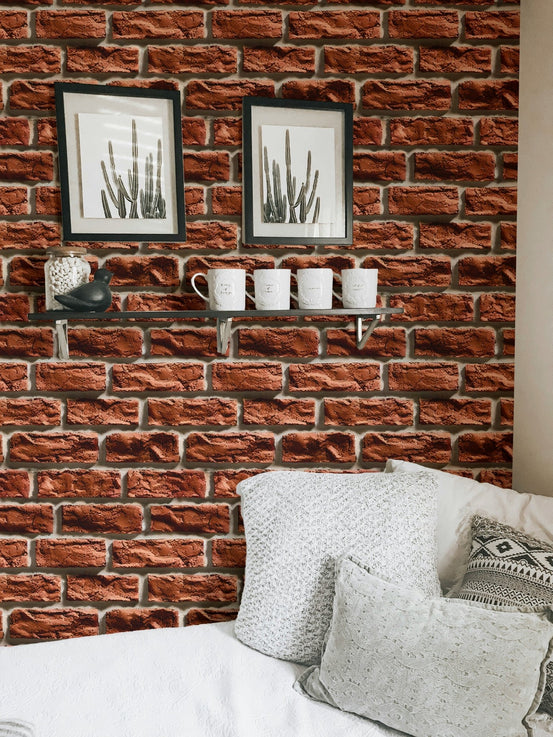 Brown brick wallpaper in a living room with white pillows and framed art.