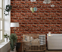 Earthy textured wallpaper in a nursery with a wooden crib and white furniture.