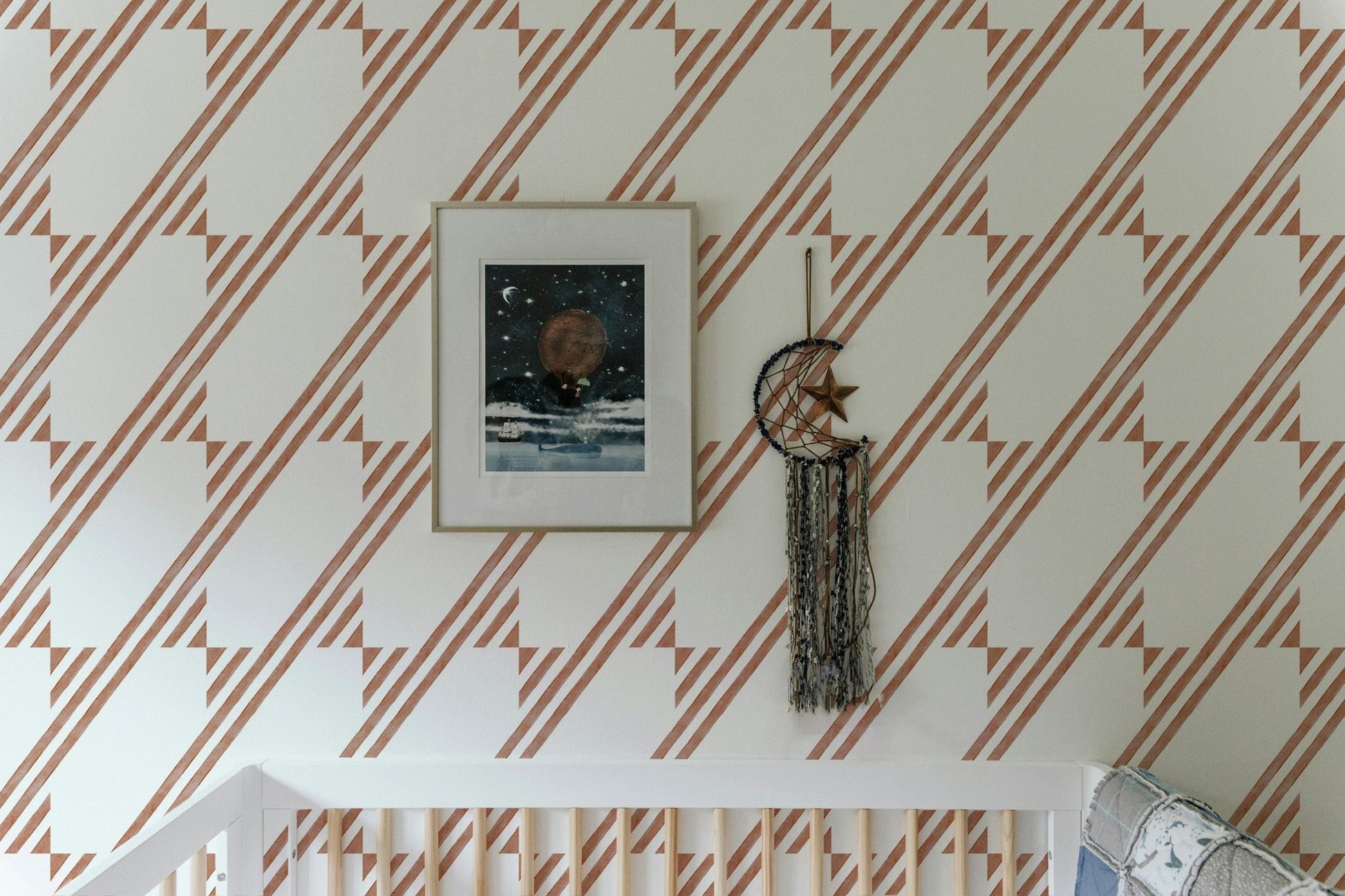 Wallpaper with terra cotta geometric stripe behind a framed art piece.