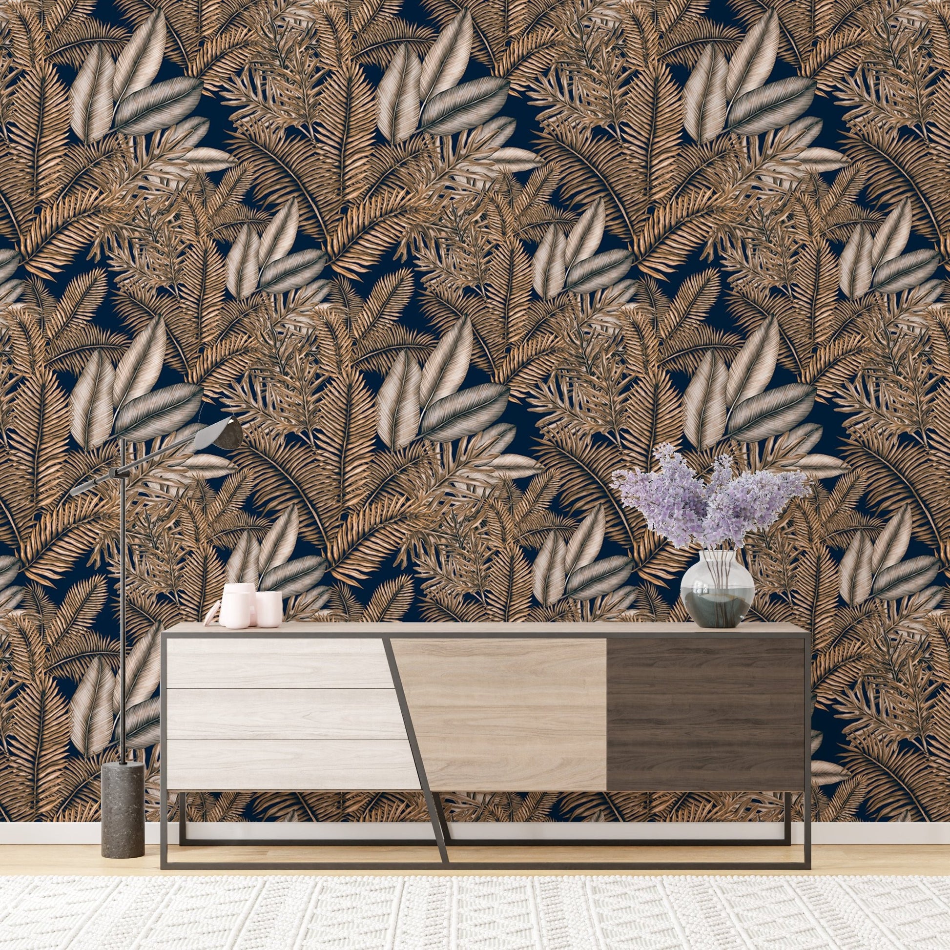 Tropical dry leaves wallpaper behind a modern wooden sideboard cabinet.