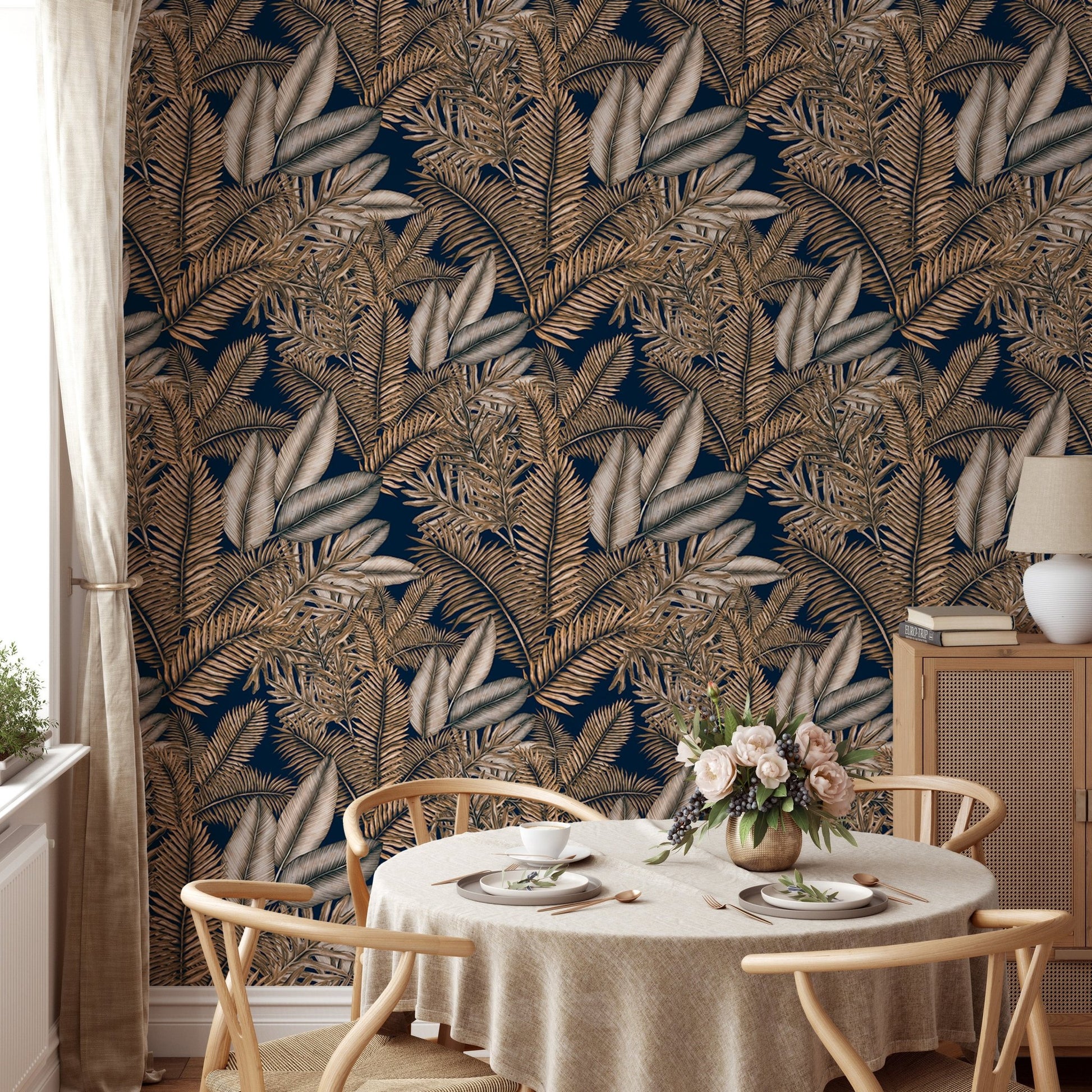 Brown color dry leaves wallpaper in a sunlit dining space with wooden chairs.