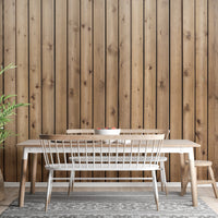 Rustic wood slat wall mural in a dining area with a long wooden table.