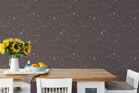 Terrazzo stone wallpaper behind a wooden dining table with yellow flowers and fruit.