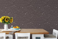 Terrazzo stone wallpaper behind a wooden dining table with yellow flowers and fruit.