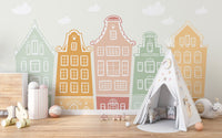 Row of pastel gabled building on a wall mural in a child's room with neutral rug.