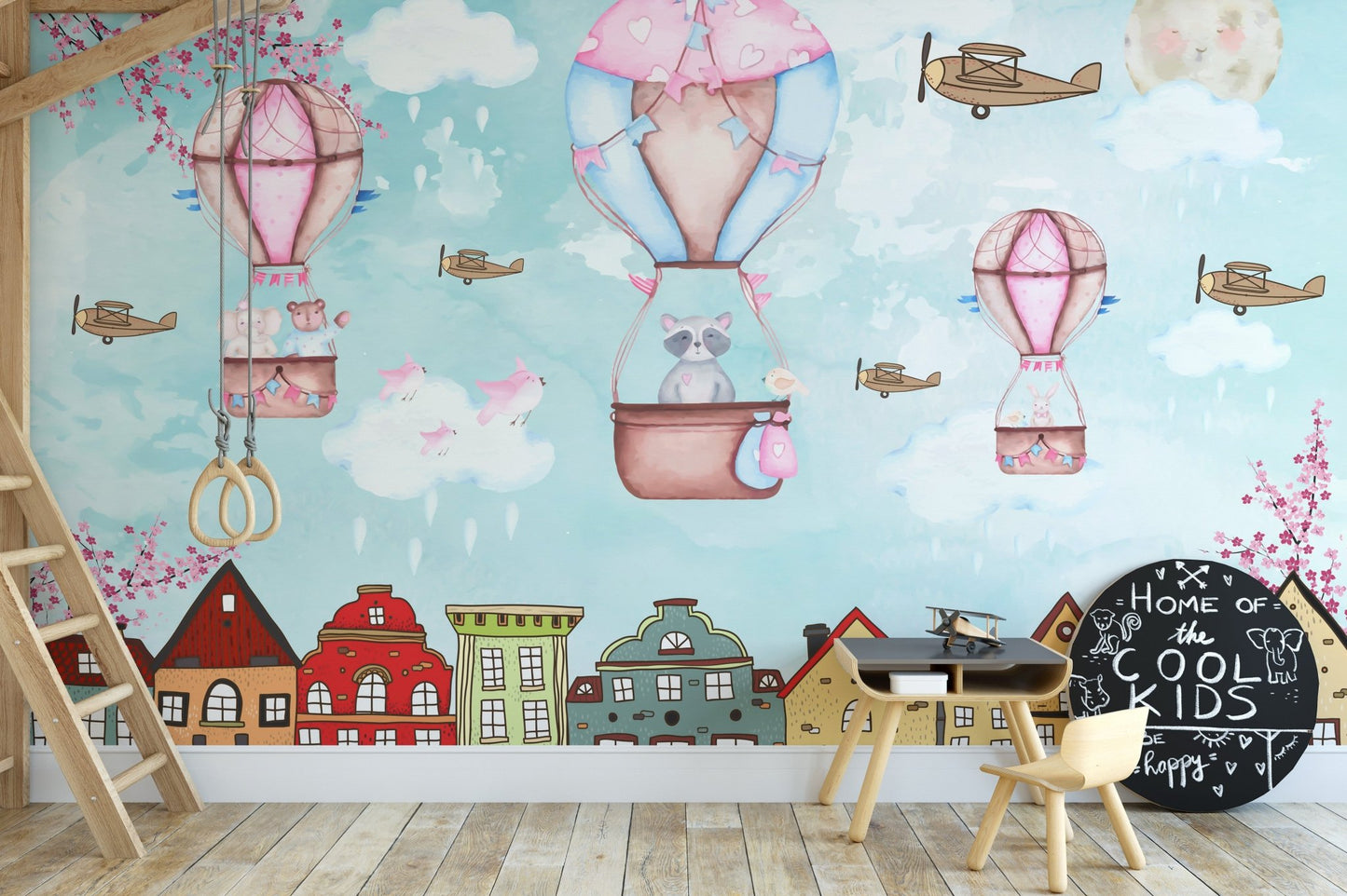 Illustration style cartoon wall mural with clouds and balloons behind a wooden study set.