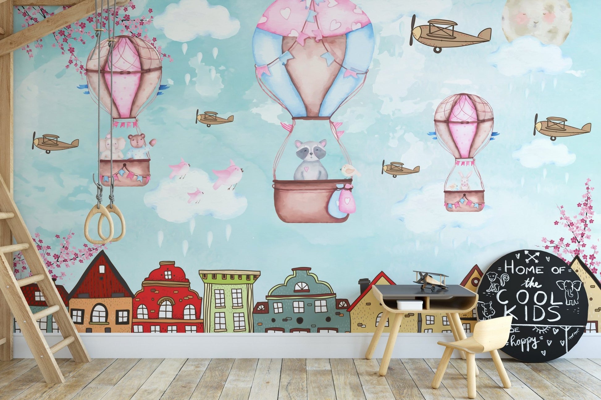 Illustration style cartoon wall mural with clouds and balloons behind a wooden study set.