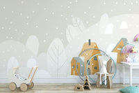 Nursery wall decor showing a wooden wagon and grey mountain wall murals.