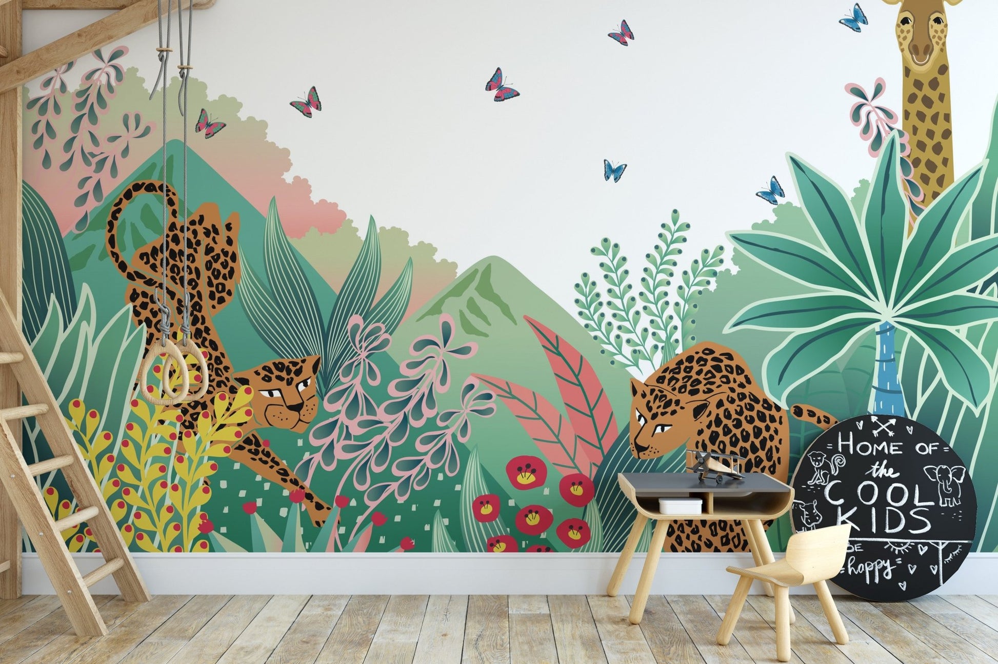Jungle safari wall mural in a playroom with a small wooden table and stools.