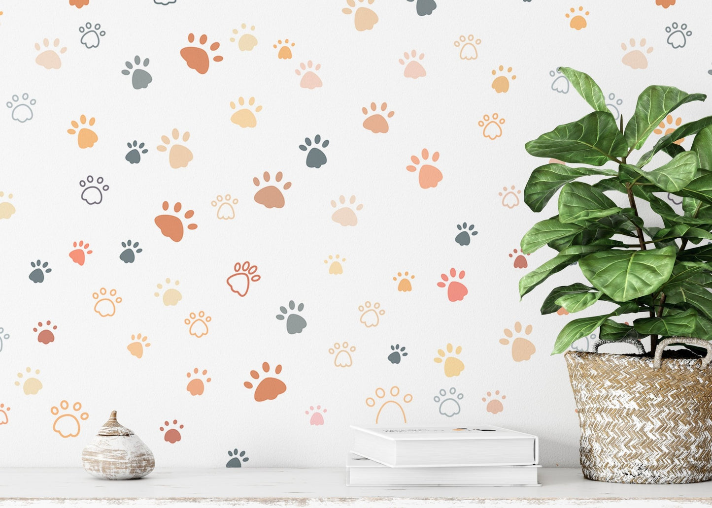 Scattered paw print wallpaper next to a large potted green plant.