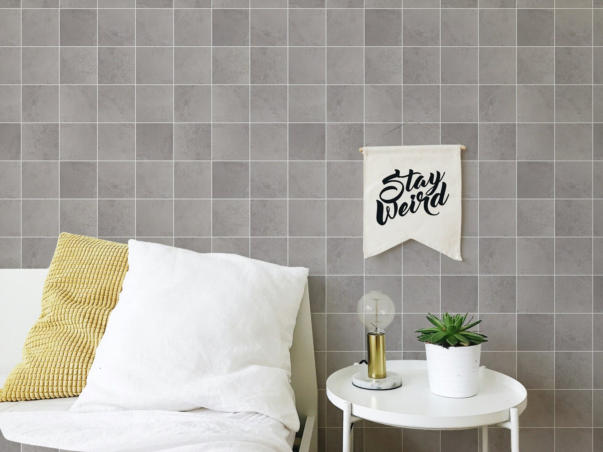 Grey tile pattern wallpaper on a bedroom wall with white pillows.