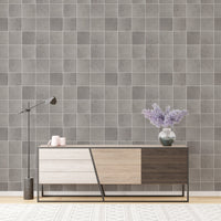 Minimalist grey tile wallpaper behind a modern wooden sideboard.