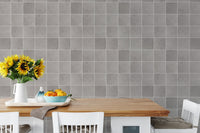 Ceramic grey tiles wallpaper in a dining space with yellow flowers.