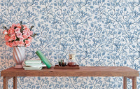 Classic nostalgic botanical wallpaper behind a wooden table with flowers