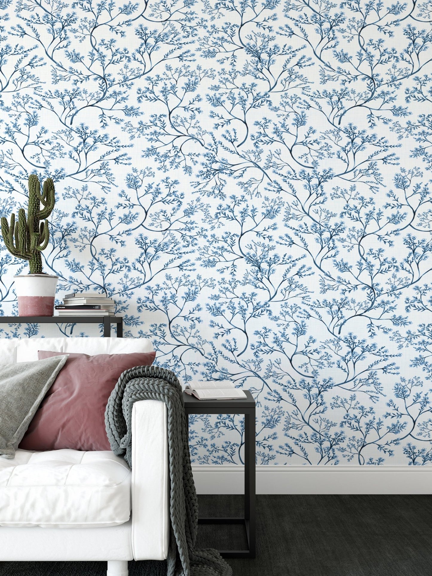 Flower wallpaper in a living area with a white sofa and indoor cactus