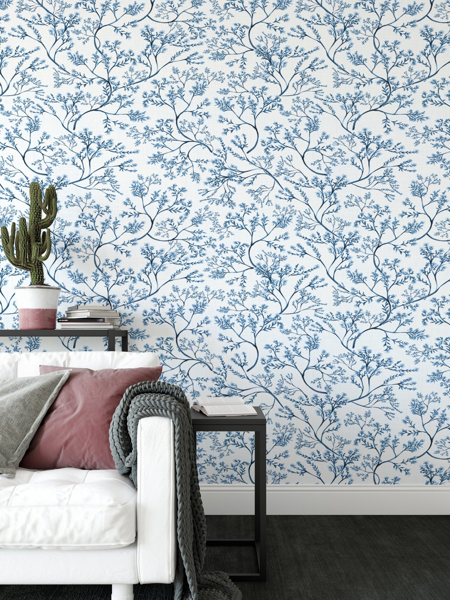Flower wallpaper in a living area with a white sofa and indoor cactus