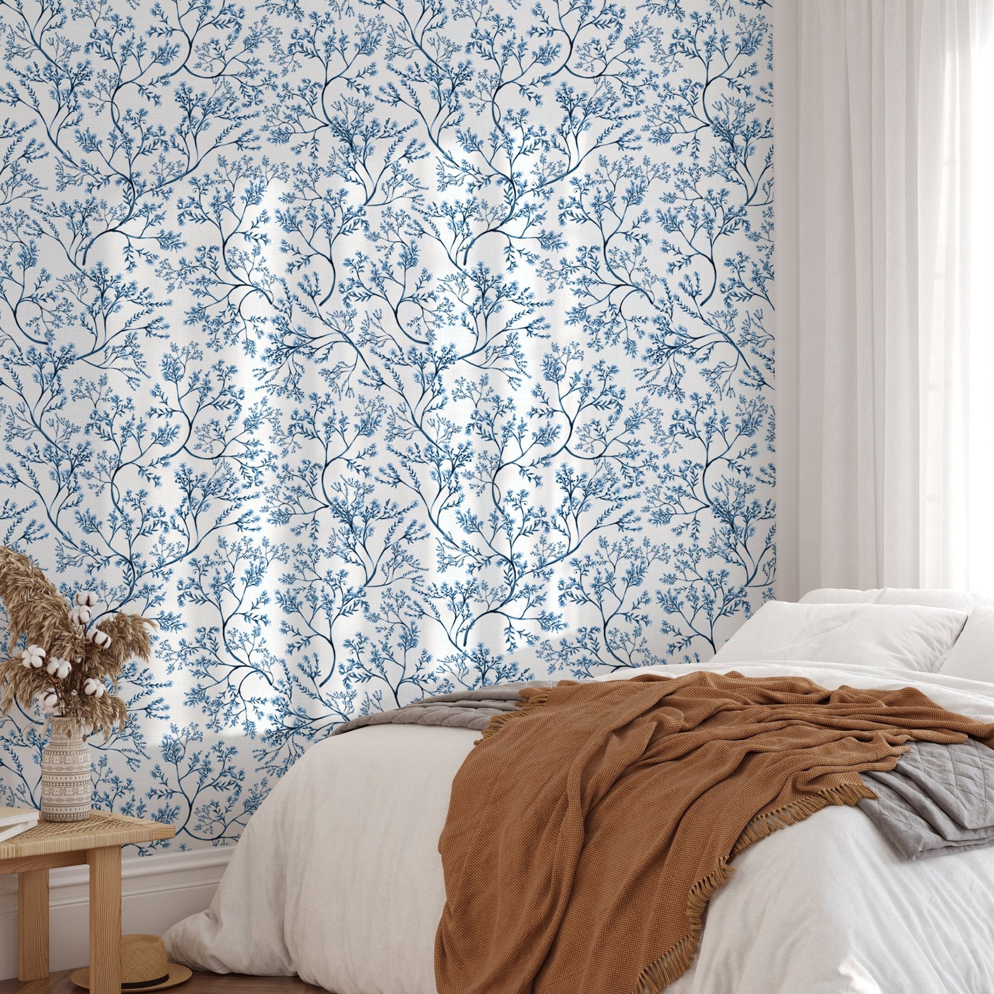 Chinoiserie wild flower wallpaper in a bedroom with a white bed and brown throw