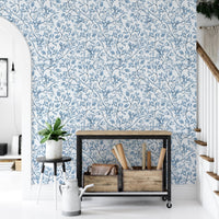 Nostalgic botanical wallpaper in an entryway with a black console table