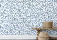 Chinoiserie wild flower wallpaper behind a wooden bench and baskets
