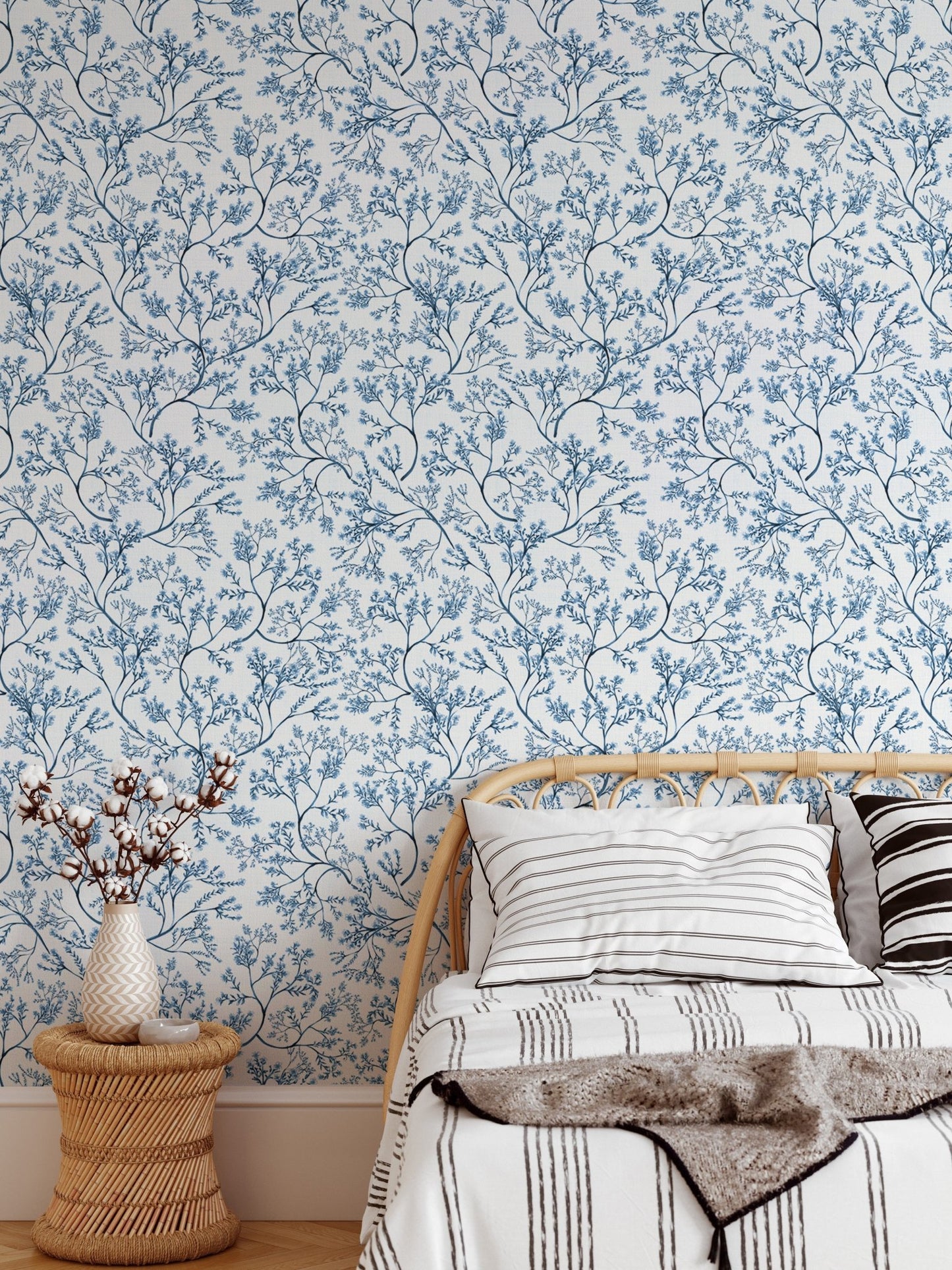 Botanical flower wallpaper on a bedroom wall with a light wooden bed frame