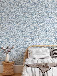 Botanical flower wallpaper on a bedroom wall with a light wooden bed frame