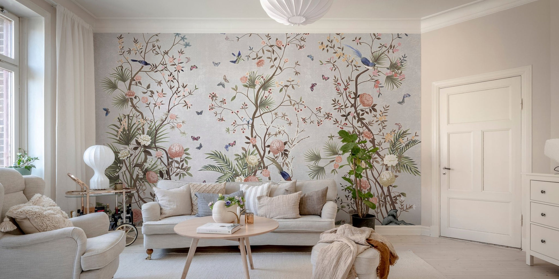Botanical flower wall mural behind a tan leather couch in a modern living area.