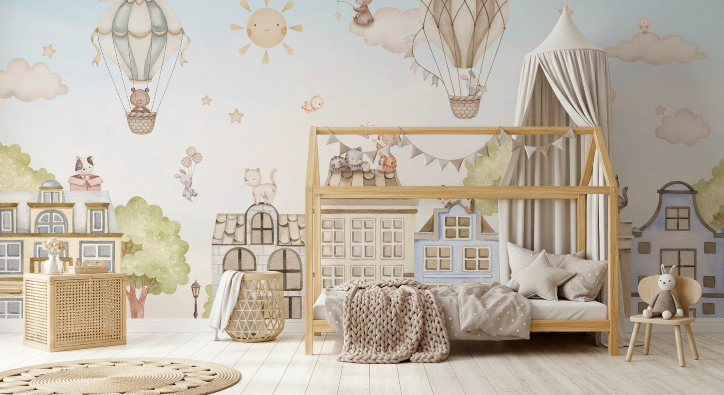 Soft blue wall mural with cat characters and houses behind a wooden house-bed.