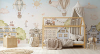 Soft blue wall mural with cat characters and houses behind a wooden house-bed.