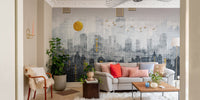 Grey and gold city skyline wall mural in a living room with a red accent pillow.