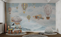 Vintage tan biplane flying over blue mountains wall mural for study room.