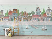 Soft watercolor coastal village wall mural with pastel buildings.