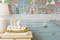 Pastel waterfront town wallpaper mural with sailboats and ducks.