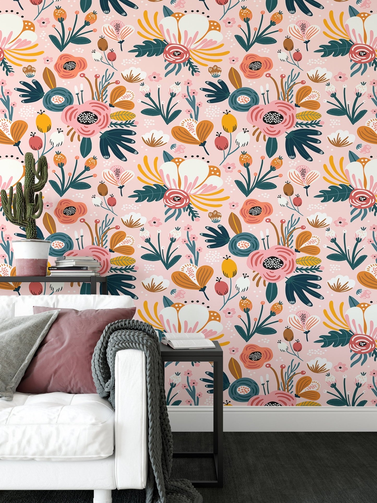 Pink floral pattern wallpaper behind white sofa and grey cushions in living space.