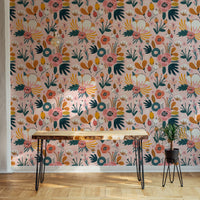 Pink floral wallpaper behind wooden desk and black metal legs in home office.