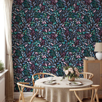Detailed flower wallpaper behind a round dining table and wooden chairs.