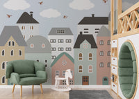 Green armchair and hobby horse in front of a blue sky city houses wall mural.
