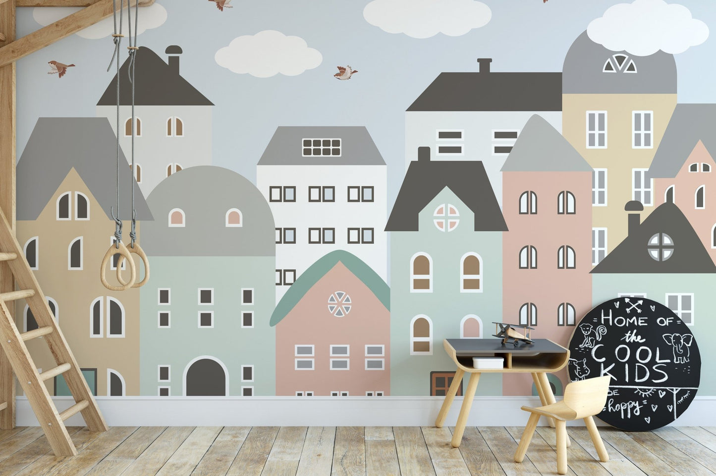 Activity area with a small wooden table set against a house pattern wall mural.