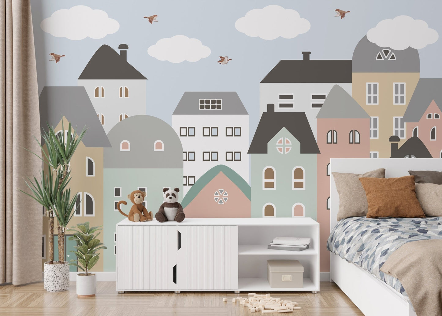 Cityscape houses wall mural behind a white unit and potted plant in a bedroom.