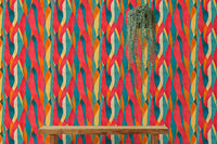 Bold vertical dyed pattern wall mural behind a wooden bench and hanging planter.