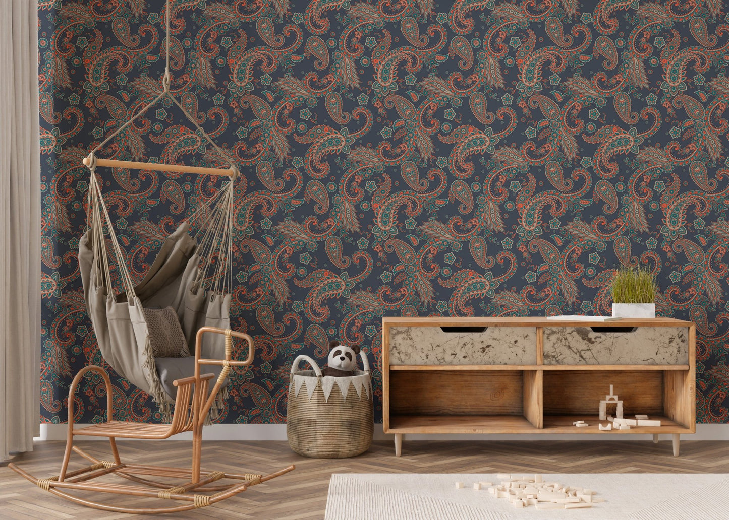 Patterned wallpaper behind a wooden cabinet and hanging chair in a nursery.