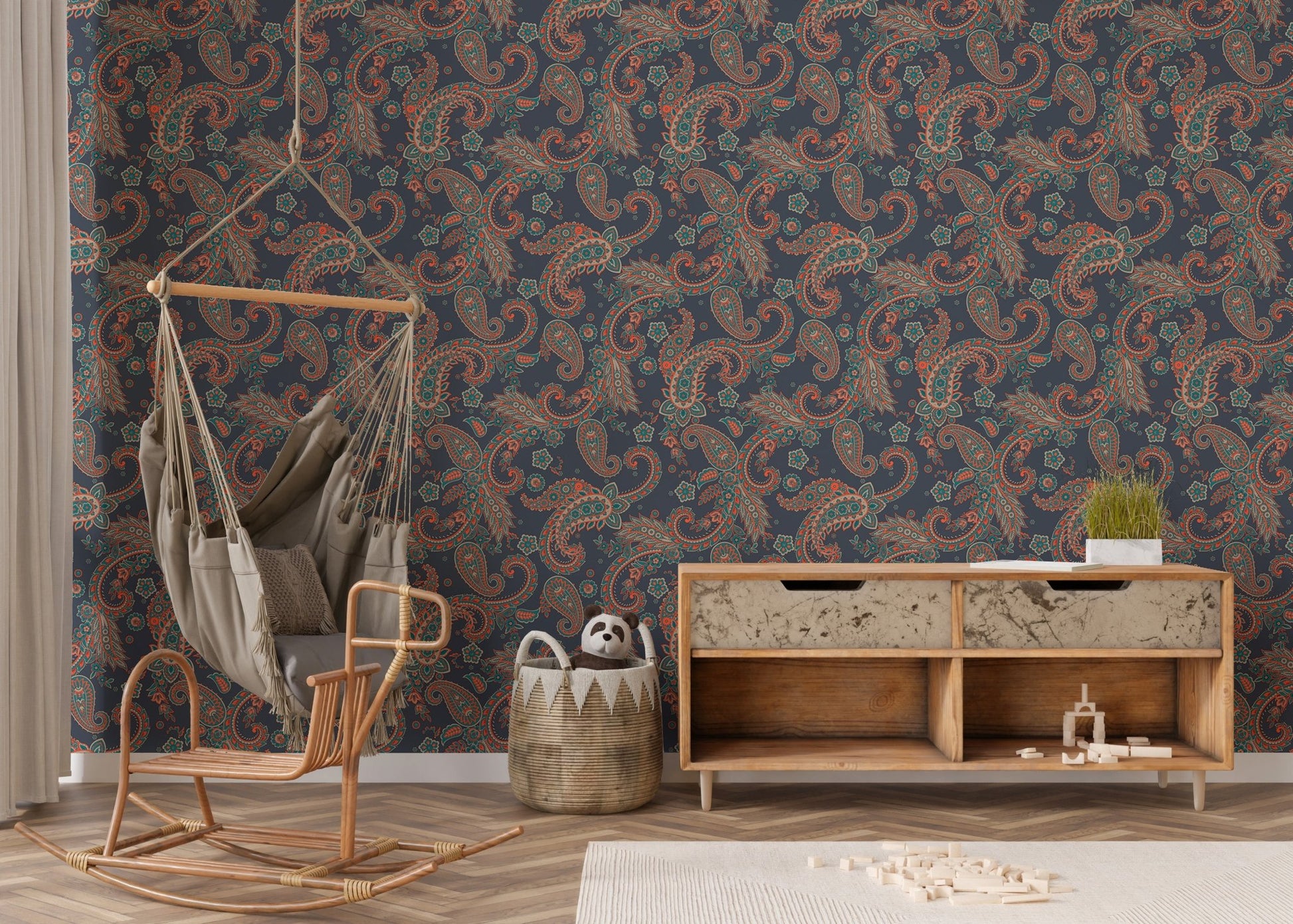 Patterned wallpaper behind a wooden cabinet and hanging chair in a nursery.