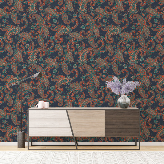 Wallpaper with paisley pattern behind a wooden sideboard and purple flowers.