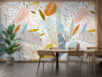 Open plan dining room with botanical leaf wall mural and natural wood furniture.