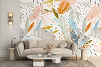 Contemporary seating area with textured leaf wall mural and beige couch.