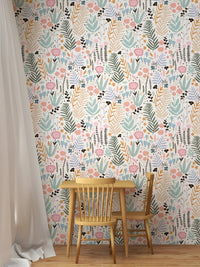 Kid's dining area with a wooden table and chair against a leaves pattern wallpaper.